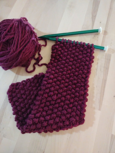 A partly finished scarf, still on knitting needles