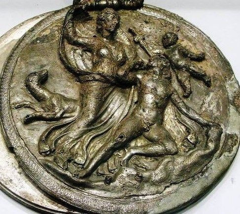 Circular relief of Selene, who is in the centre, one arm raised holding up her billowing cloak. Below her, Endymion kneels on the ground, his hunting dog prancing behind Selene. Eros flies in the air to the right, taking away Endymion's sword.