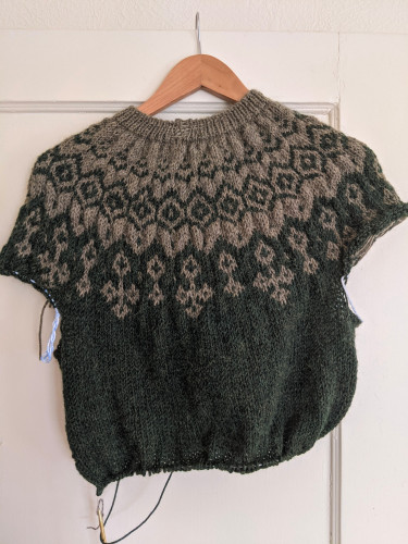 A yoke down color work sweater in warm lichen gray and rich mossy green