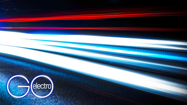 A time-lapse photo of car lights streaking by at night. In the bottom left is the NMR Online - ELECTRO logo, in the "GO" formation, with "electro" written inside the "O"