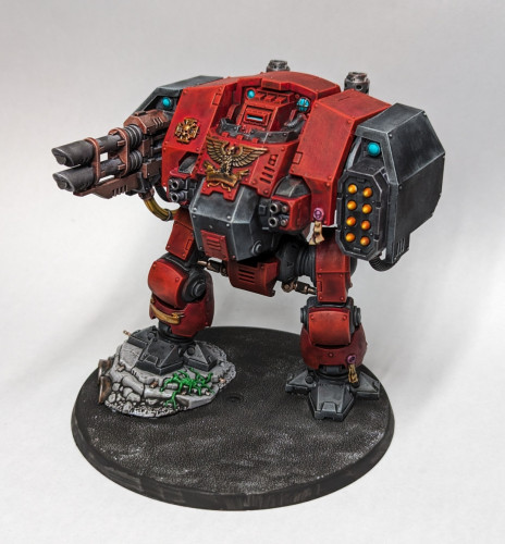 Warhammer 40k Space Marine Dreadnought primed with initial color painted on, mostly reds and blacks, with gold details.