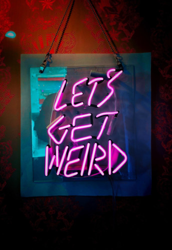 Pink neon sign saying let’s get weird 