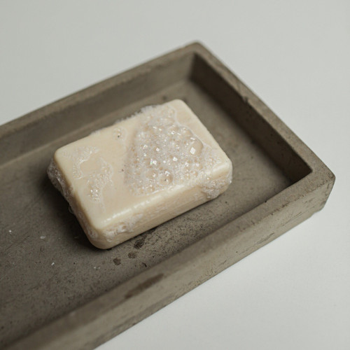 A bar of soap in a wooden soap dish