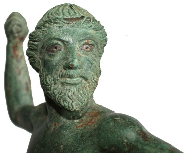 Bronze statuette of Zeus, shown in full heroic nudity. His left arm and foot are thrust dynamically forward in the direction of his foes, while his right leg is straight; the arm is raised and slightly bent, implying movement. His weight falls on his left forward leg, but the figure is balanced and poised. His left arm is held straight before his body. He may have held an eagle on his missing left hand, while his right arm is bent at a right angle to throw the thunderbolt, which is also missing.