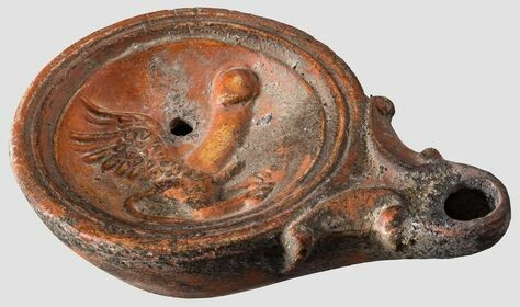Roman oil lamp of the Loeschke IV type with an erotic decoration: A winged, legged phallus with a little phallus of its own.