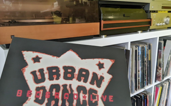 Record (vinyl) of Urban Dance Squad - Beograd Live. Turntable set-up in the background: two turntables side by side and an amplifier next to it.