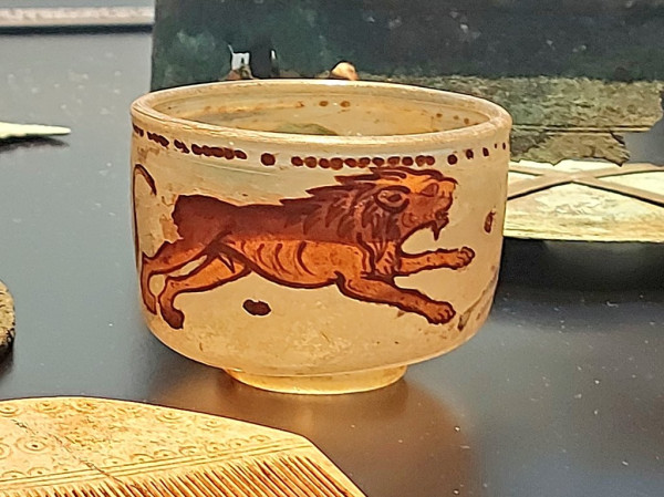 The picture shows a glass cup painted with a lion.