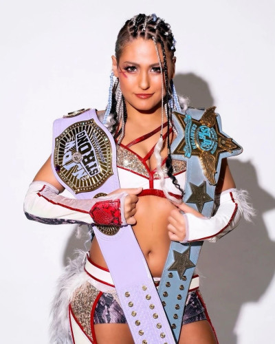 STARDOM wrestler Giulia, with her NJPW Strong Womens title belt and Artist of STARDOM belt.