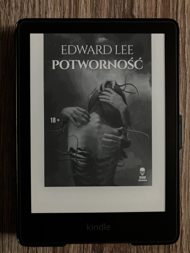 Okładka książki "Potworność" Edwarda Lee. Urządzenie Kindle Paperwhite.