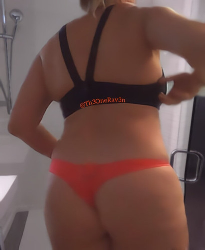 Photo from behind of woman in black sports bra and an orange thong. Booty is hungry!