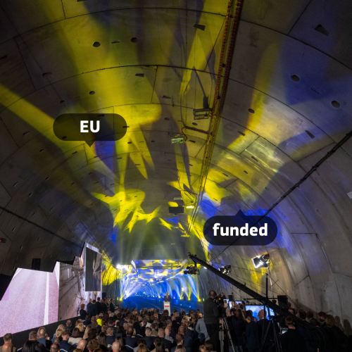 A photo of the Świnoujście Tunnel in Poland during the inauguration. 
 
The European flag was projected over the arc of the tunnel while people were taking part in the inaugural ceremony.

(Inauguration of the Świnoujście Tunnel in Poland, picture alliance, Getty Images)
