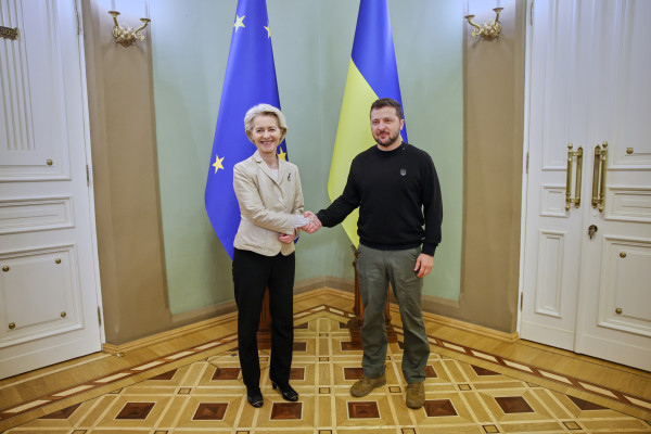 Photo of President von der Leyen shaking hands with President Zelenskyy. The EU and Ukrainian flags stand behind them.
