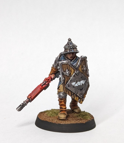 A Warhammer Age of Sigmar human footsoldier mini with his fantasy weapon removed and replaced with a Warhammer 40k lasgun. Painted in blues, khakis, and silver then washed with brown shade paint to get appropriately dirty. His shield has an Imperial Aquila but didn't look likely to stop a blast from a plasma weapon.