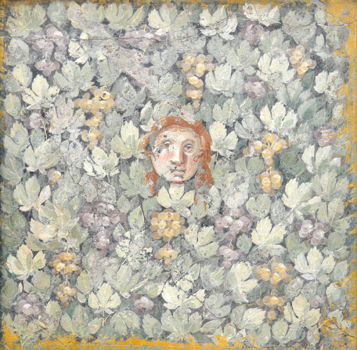 A section of fresco showing grape vines and grapes growing across a wall. A mask with a sombre expression emerges from between the leaves in the centre of the panel.