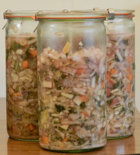 Three tall, cylindrical 1.5-liter canning jars filled with packed chopped vegetables in liquid, the vegetables a pale green in color.