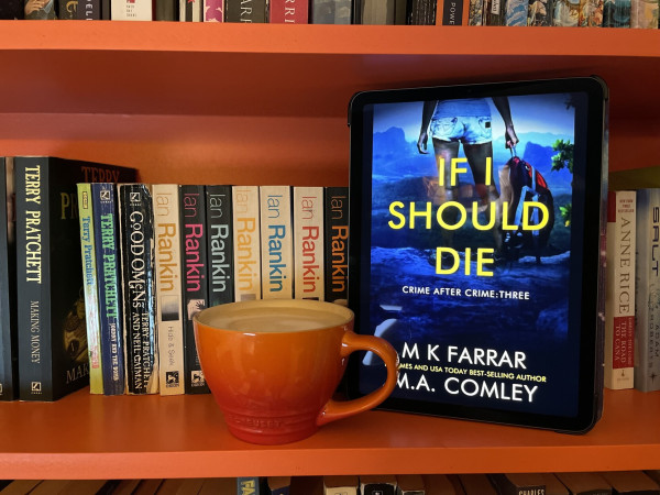 Orange bookshelves with a cup of coffee and my iPad, showing If I Should Die by MK Farrar and MA Comley. 
